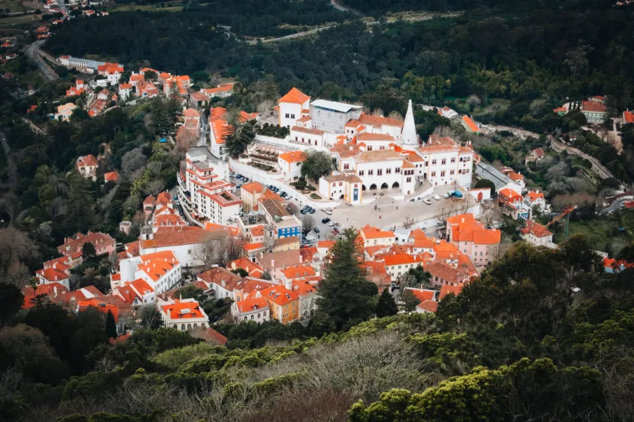 Aerial view of Sintra with red rooftops and the iconic palace with twin conical towers