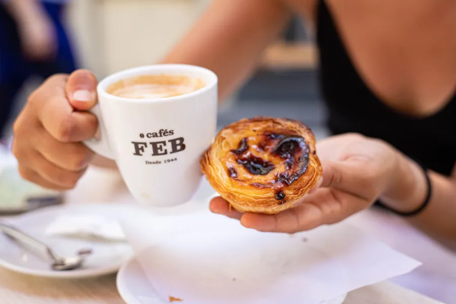 Coffee cup and pastel de nata on a café table